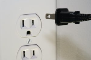 plug going into electrical outlet plug going into electrical outlet